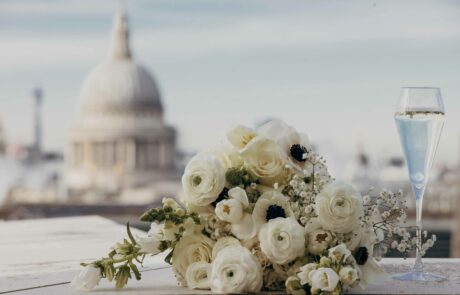 A bridal bouquet lies on the ledge of the Wagtail terrace, filled with roses, anemones, lisianthus and baby's breath flowers, in the background, St Paul's iconic dome is visible.